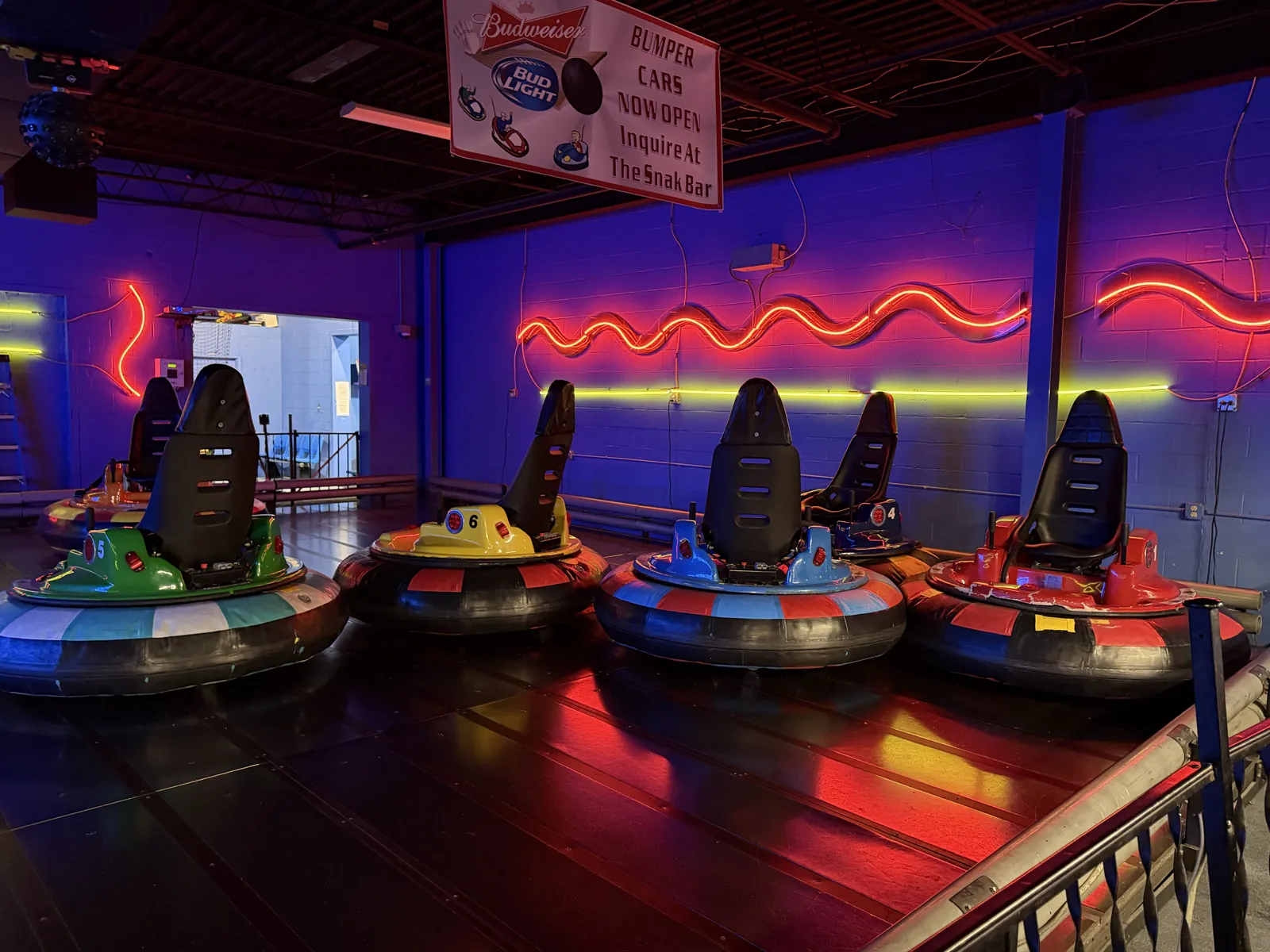 Colorful bumper cars parked inside the illuminated Southern Lanes rink