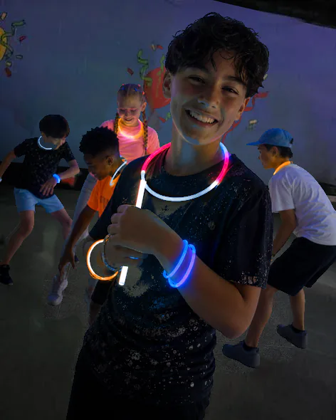Smiling group wearing glow necklaces during black-light play